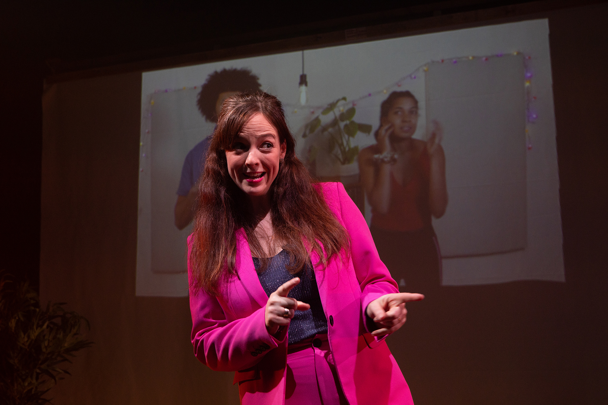 a woman playfully pointing at someone off camera